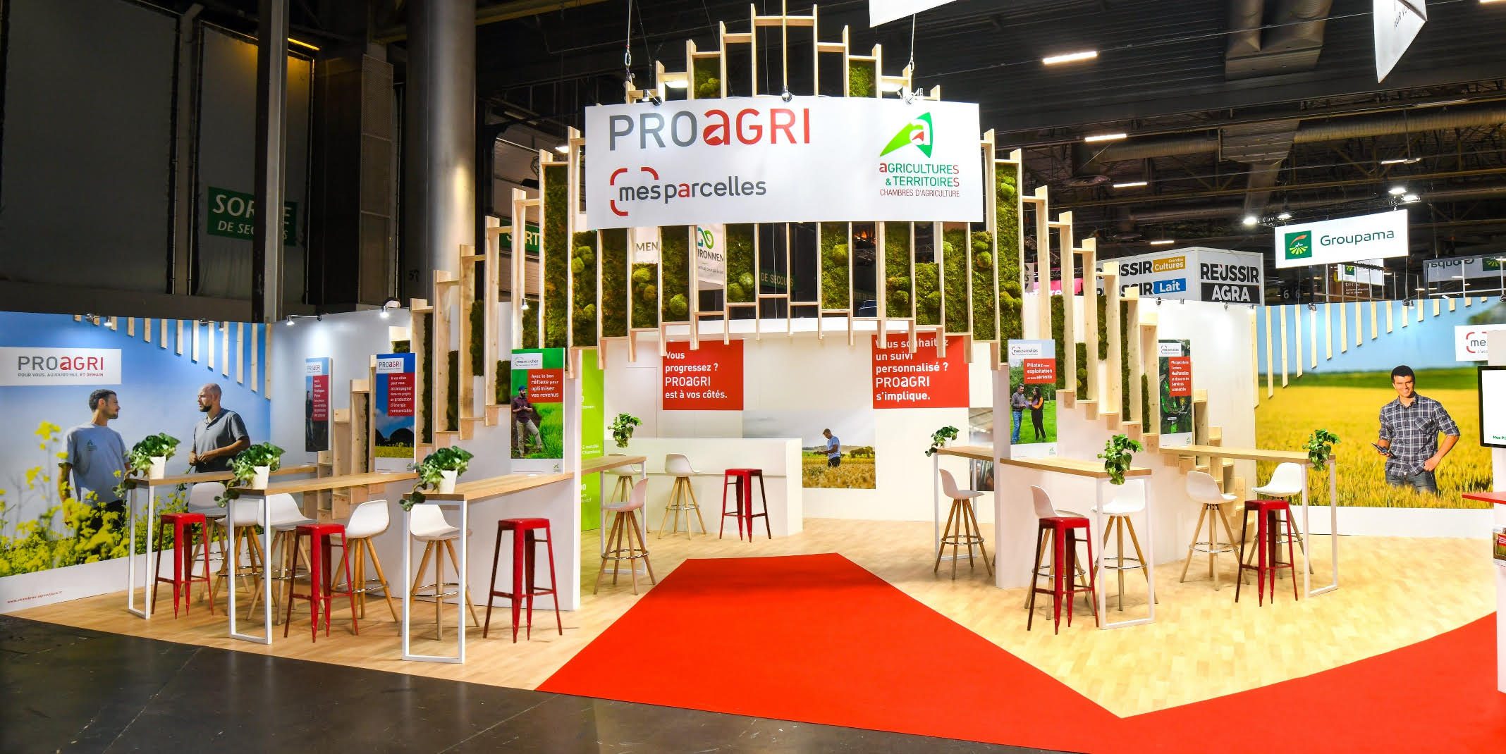 Stand éco responsable avec grand mur végétal, design en bois et enseigne haute